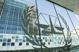 Exterior of the International Criminal Court (ICC) in The Hague, Netherlands, showing the court’s emblem on a glass facade.